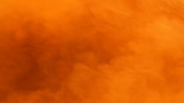 Orange smoke cloud texture fills abstract background with soft hazy color