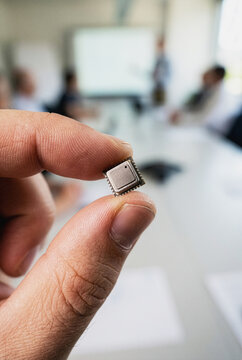 Microchip held between fingers