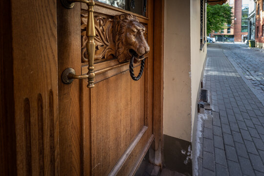 Carved Lion Door Knocker Adorns an Ornate Wooden Entrance
