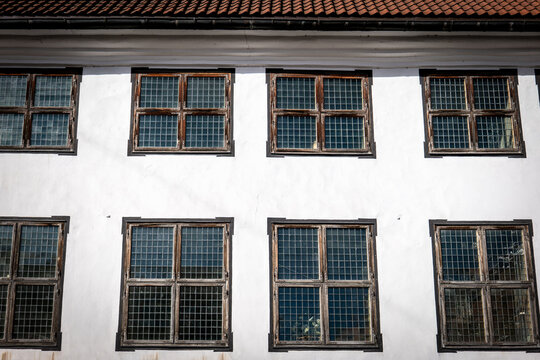 Weathered Wooden Windows Line a Sunlit Historic Building Facade