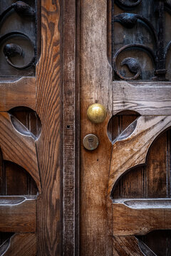 Ornate Wooden Double Door with Iron Scrollwork and Brass Knob