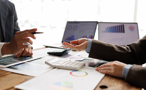 Business people collaborating on financial analysis, discussing market data, accounting reports, and economic trends during a meeting, calculating strategies for growth