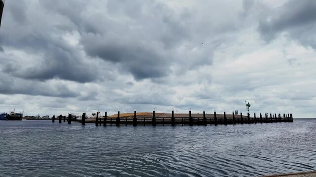 Wooden breakwater and North Sea under a dramatic cloudy sky on Texel, Netherlands