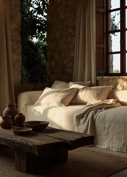 Cozy bedroom with a large window on the right side. the window is covered with white curtains and has a view of trees and greenery outside.