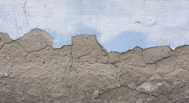 Peeling blue paint revealing rough concrete wall texture
