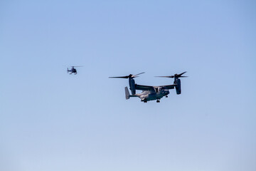 V-22 Osprey military tiltrotor aircraft flying against a clear blue sky, photographed in side profile with its distinctive twin rotors, engines, wings and rear fuselage clearly visible. © Ian Scott