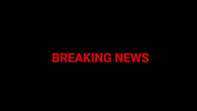 Breaking news caption displays in vibrant red characters on a deep black field to capture audience attention during urgent reporting segments.