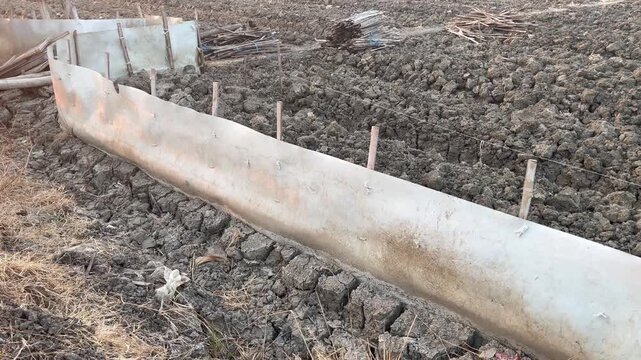 Traditional rice field protection using plastic tarpaulin and wooden stakes