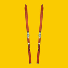 set of two vintage weathered skis on a yellow background