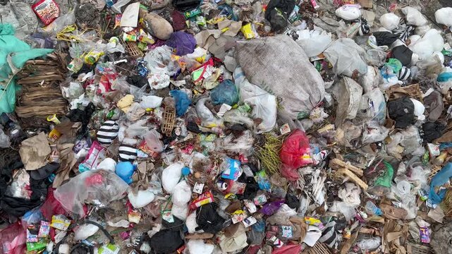 Heavy plastic waste and domestic garbage polluting a completely dried riverbed