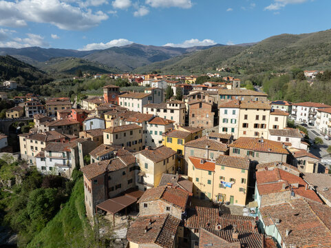 Aerial view of the historic village of Loro Ciuffenna with its traditional stone buildings, terracotta rooftops, and surrounding lush hills in Loro Ciuffenna, Tuscany, Italy.
