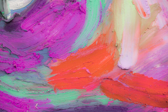 Mixing oil pastels to create a colorful blend on paper in a close-up view