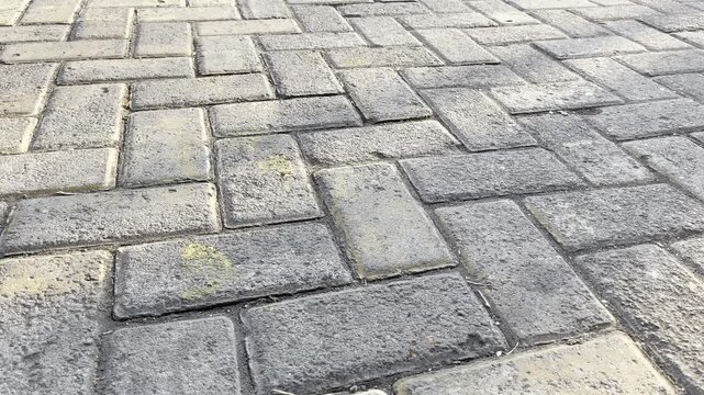 Close up of weathered brick paving blocks pattern on urban sidewalk