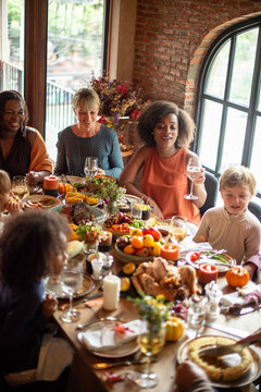 Diverse women and children sharing a festive family dinner table