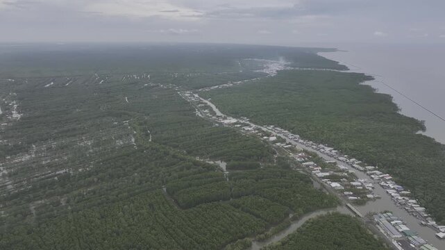 Aerial drone view of Mui Ca Mau National Park in Dat Mui, Ca Mau, Vietnam, featuring the national flagpole and coordinate marker surrounded by sunlit mangrove forests.