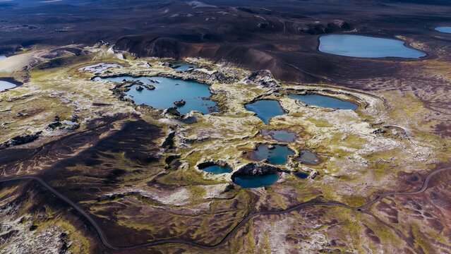 Aerial view of Litlisjor lake surrounded by volcanic mossy terrain and dark lava fields in Rangarthing ytra, Iceland.