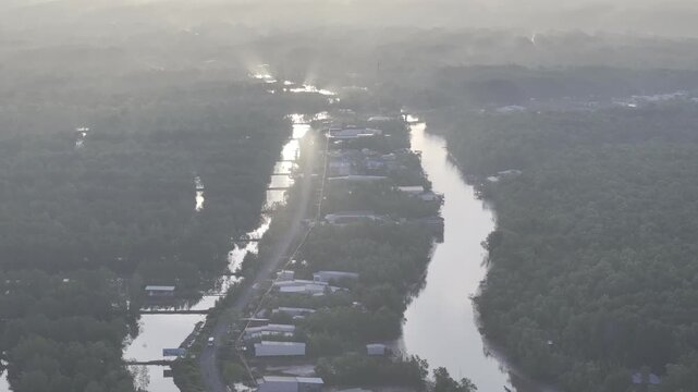 Aerial drone view of Mui Ca Mau National Park in Dat Mui, Ca Mau, Vietnam, featuring the national flagpole and coordinate marker surrounded by sunlit mangrove forests.