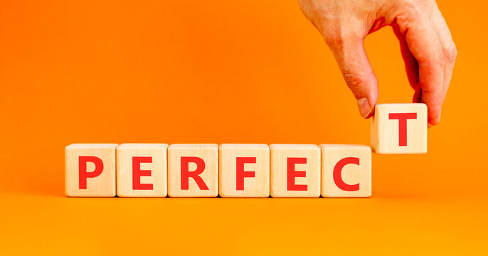 Perfect word symbol. Concept word Perfect on beautiful wooden blocks. Beautiful orange table orange background. Businessman hand. Business perfect word concept. Copy space.