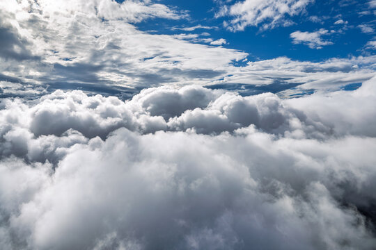 Breathtaking view of white fluffy clouds filling the blue sky, captured from high altitude during bright daylight.