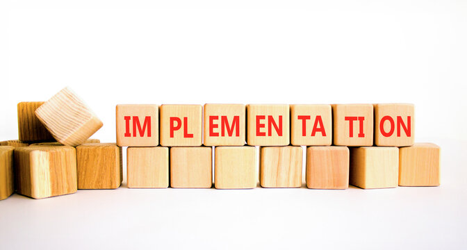 Implementation word symbol. Concept word Implementation on beautiful wooden blocks. Beautiful white table white background. Business implementation word concept. Copy space.