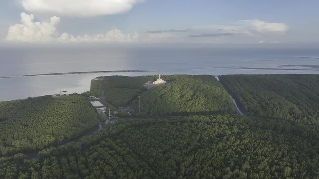 Aerial drone view of Mui Ca Mau National Park in Dat Mui, Ca Mau, Vietnam, featuring the national flagpole and coordinate marker surrounded by sunlit mangrove forests.