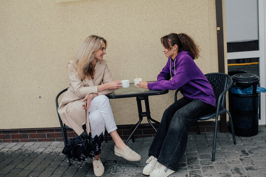 Two sisters spending time together drinking coffee and walking in autumn