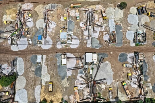 Aerial view of the Gabtoli stone crushing plant featuring industrial machinery, conveyor belts, and piles of gravel and sand, Dhaka, Dhaka Division, Bangladesh.