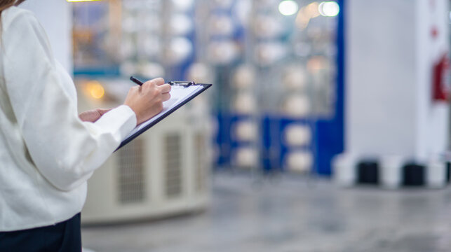 Quality Control Inspector Writing on Clipboard in Textile Factory