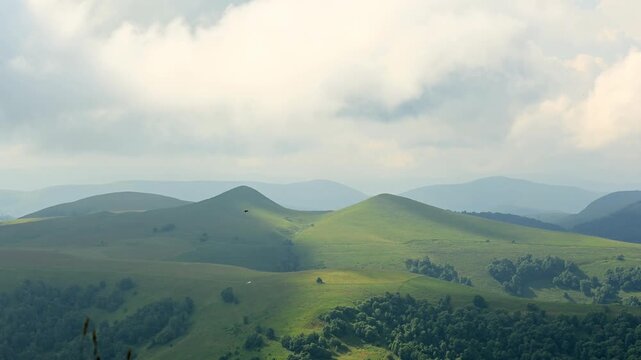 Cloud shadows moving across green mountain hills