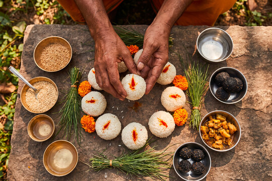 Hands preparing traditional sacred rice offerings for Hindu ancestor ritual