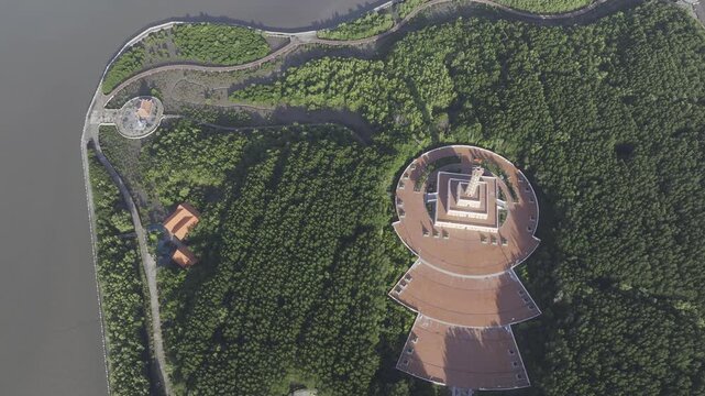 Aerial drone view of Mui Ca Mau National Park in Dat Mui, Ca Mau, Vietnam, featuring the national flagpole and coordinate marker surrounded by sunlit mangrove forests.