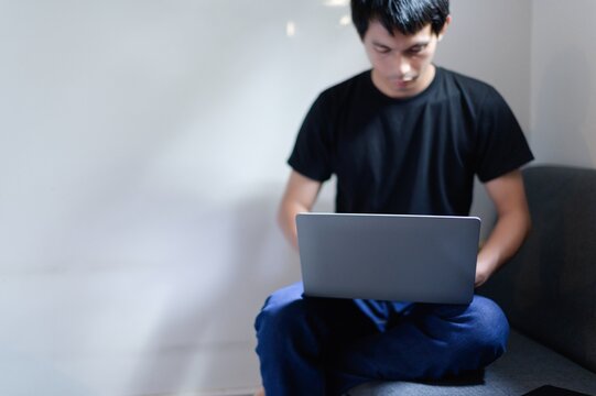 Young Man Working on Laptop in Casual Home Environment