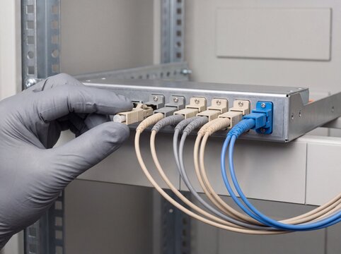 Technician Auditing a Fiber Optic Patch Panel in a Network Cabinet