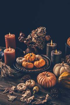 Autumn harvest bounty with glowing candles and rustic wooden table setting