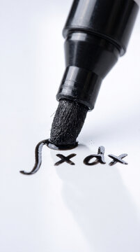 Extreme macro close up of a black marker writing a math integral equation on a white board.