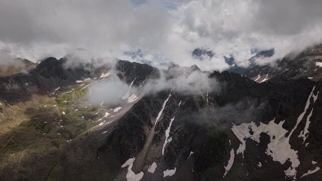 Aerial view of mountain range with shifting clouds