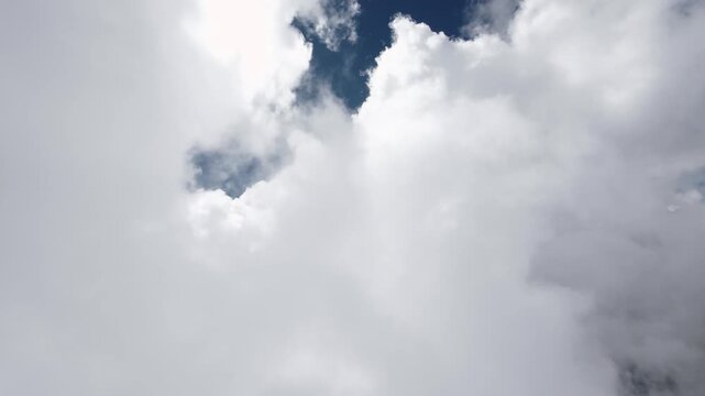 Fast flight through white clouds and blue sky