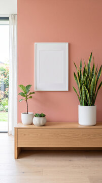 White framed blank mockup on a peach wall, showcasing potted plants on a wooden console, symbolizing modern interior design and home decor