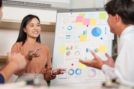 Asian businesswoman presenting quarterly financial strategy in office meeting
