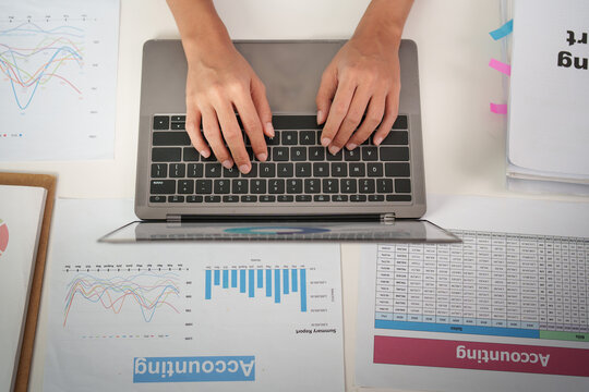 Overhead view of person typing on laptop for accounting and business data analysis