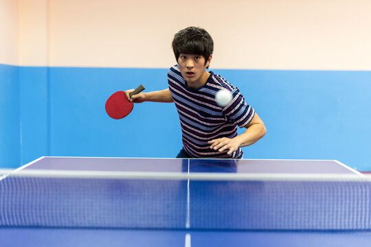 Focused table tennis player action.
