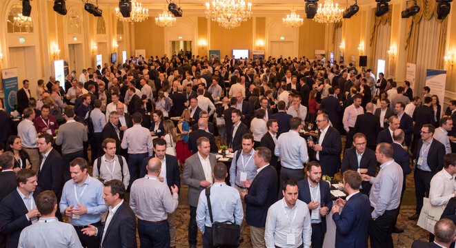 Business event photo showing diverse professionals networking at a crowded conference reception