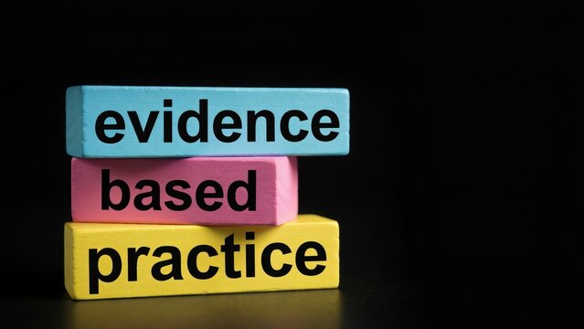 Colorful wooden blocks spelling out evidence based practice against a dark background. Professional concept image for healthcare and business education.