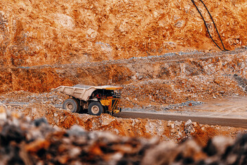 Heavy duty dump truck in orange open pit quarry for industrial banner and background design focused on mining transport © Parilov