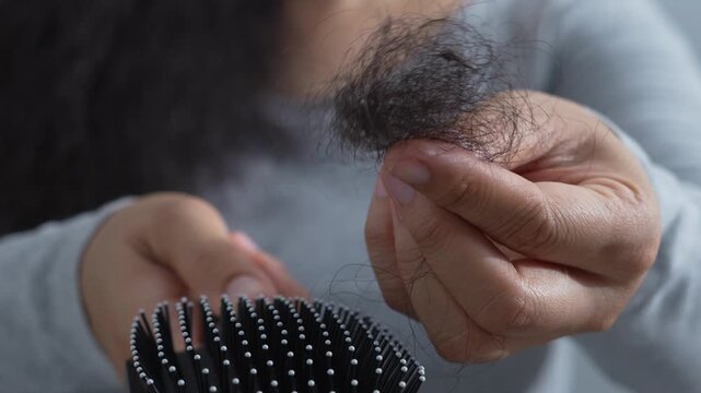woman sticking brushing her hair falling out and have many hair loss on the comb. problem of Damaged and frizzy. Healthcare and medical concept.	