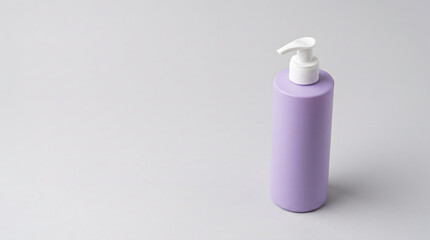 Purple cosmetic pump bottle standing upright with a white dispenser nozzle top © ChaohM