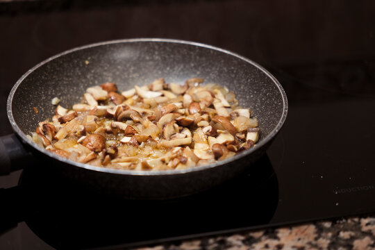 Sauteing portobello mushrooms and onion in frying pan.