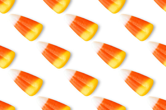 Repeating seamless pattern of candy corn pieces on transparent background