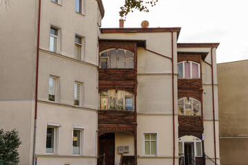 Fototapeta premium Historical residential building facade featuring intricate wooden balconies, ornate vintage woodwork, urban architectural detail, exterior perspective