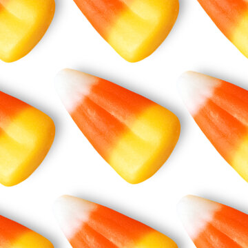 Repeating seamless pattern of candy corn pieces on transparent background